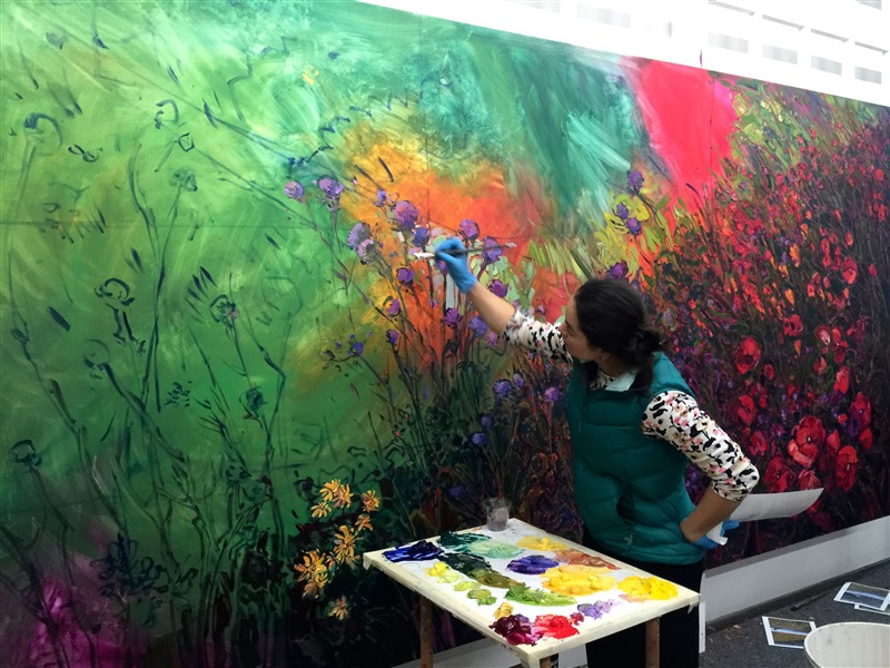 Erin Hanson painting a mural-sized oil painting landscape in her studio, in Los Angeles